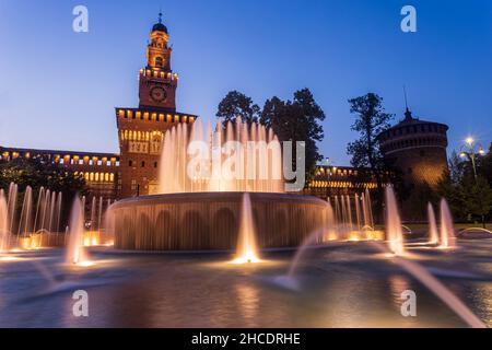 Fontaines d'eau en face du château de Sforza (Castello Sforzesco) vu pendant l'heure bleue du coucher du soleil.Photo prise le 19th août 2021 à Mila Banque D'Images