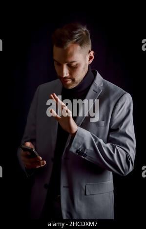 110 / 5 000 portrait d'un jeune homme d'affaires qui a un appel vidéo sur son téléphone intelligent et se gestuelle en parlant Banque D'Images