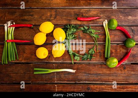 Ingrédients frais et arrangés avec goût en épelant le mot «nourriture» sur une table en bois Banque D'Images