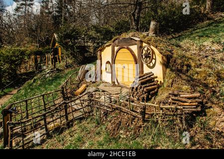 Maison Hobbit en tchèque Hobbiton avec trois trous Hobbit et de jolies portes jaunes.Maison de conte de fées dans le jardin.petit village magique du film de fantaisie Banque D'Images