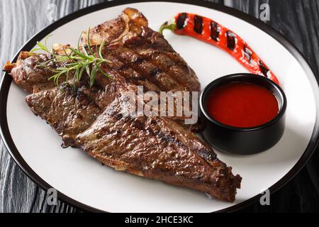 Steak barbecue grillé avec romarin frais dans l'assiette de la table noire.Horizontale Banque D'Images