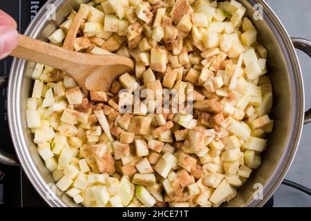 Gros plan des tranches de courgettes écrasées appétissantes en les préparant dans une casserole pour le remplissage de la tarte Banque D'Images