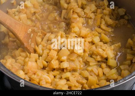 Gros plan des tranches de courgettes écrasées appétissantes en les préparant dans une casserole pour le remplissage de la tarte Banque D'Images