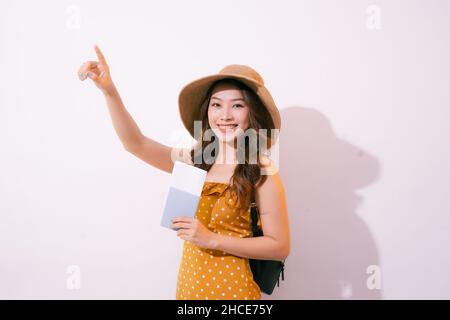 Portrait de concept de voyage d'une femme souriante tenant un passeport avec un billet montrant la pâte de copie Banque D'Images