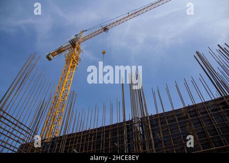 Structure en béton armé et grue à tour contre le ciel bleu.Construction de fondations.Structure en béton du chantier.Processus de construction Banque D'Images