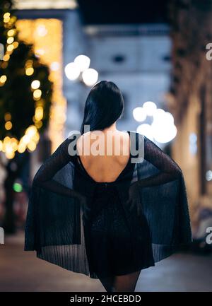 Portrait de mode de la jeune femme asiatique de l'arrière dans la rue la nuit portant une robe de fête Banque D'Images