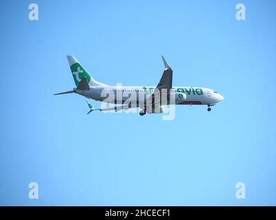 Avion Transavia avec logo vert volant au ciel bleu Banque D'Images