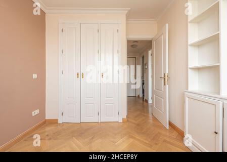 chambre avec bibliothèque en bois laqué blanc, armoire intégrée et porte avant Banque D'Images