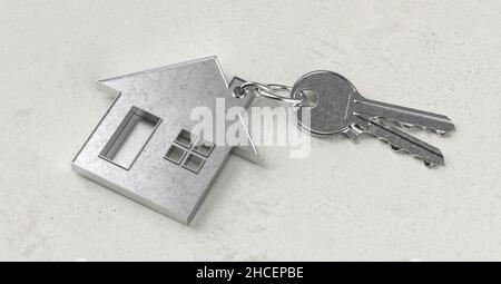Clés avec porte-clés en forme de maison sur un rez-de-chaussée en béton comme achat de maison et concept de logement Banque D'Images