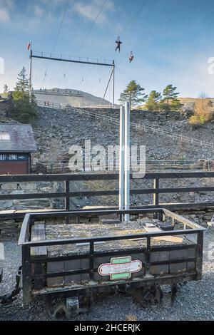 Couple,on,zip line,at,Zip World,above, Blaenau Ffestinog,is,a,Town,in,Gwynedd,Wales.autrefois un centre d'exploitation de l'ardoise, il compte maintenant beaucoup sur les touristes, attirés par exemple par le Ffestinog Railway, et, Llechwedd Slate Caverns,et Zip, World,et d'ardoise de développement profond de l'industrie touristique du nord de 12 000, a atteint une population de la mine de pays de pays de Galles.mais elle a chuté avec la baisse de la demande en ardoise. Banque D'Images