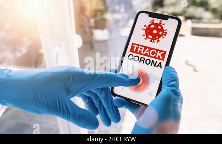 application de suivi des coronavirus sur un smartphone mobile.Gros plan d'une femme qui suit une foule de personnes dans une application d'écran de smartphone.Main tenant le smartphone Banque D'Images