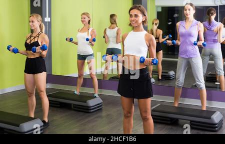 les femmes sportives pendant l'entraînement dans la salle de gym avec haltères Banque D'Images