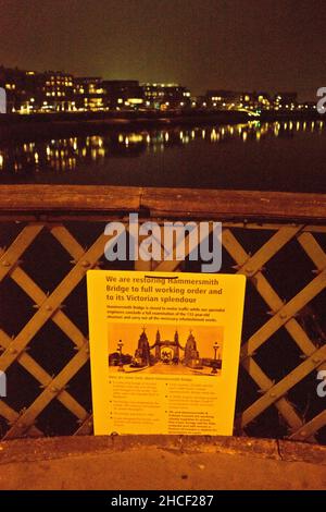 Panneau avec plans de rénovation pour Hammersmith Bridge la nuit près de la Tamise, Londres, Angleterre, Royaume-Uni Banque D'Images