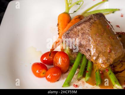 Filet de boeuf grillé aux asperges et tomates au vin rouge sa Banque D'Images