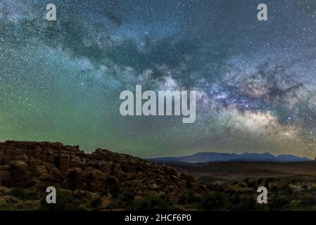 Une voie lactée bleu-vert brillante et une lueur verte au-dessus des nageoires de roche rouge de Fiery Furnace dans le parc national d'Arches, Moab, Utah. Banque D'Images