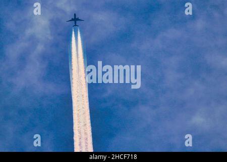 Jet et ses contrailles dans un ciel bleu Banque D'Images