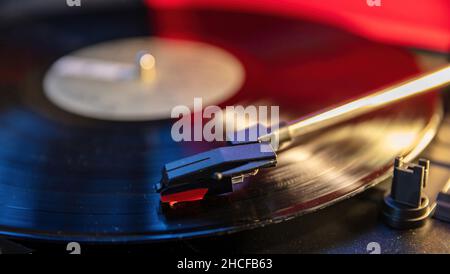 Platine vinyle lecteur de disques, disco néon fond de lumière.Aiguille sur le disque, vue rapprochée.Technologie audio, écoutez de la musique de fête vintage. Banque D'Images