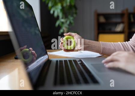 Prévention du syndrome du canal carpien.Une femme s'exerçant avec une bague de préhension sur le lieu de travail Banque D'Images