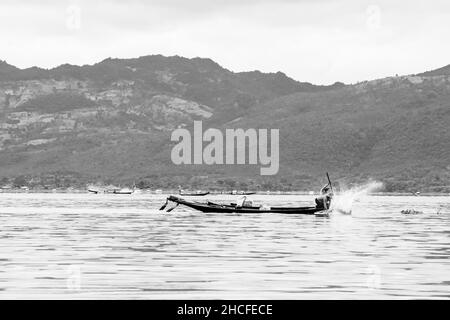 Un birman, à la pointe du bateau ou du kayak, pêchant avec des filets et manvolant son bateau au lac Inle Banque D'Images