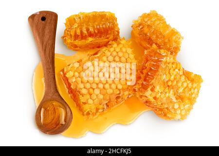 Nid d'abeilles et flaque de miel avec cuillère en bois isolée sur fond blanc avec passe-cheveux et profondeur de champ totale.Vue de dessus.Pose à plat Banque D'Images