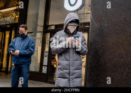 New York, États-Unis.27th décembre 2021.Les gens attendent dans une file d'attente au site mobile de test COVID-19 dans Midtown Manhattan.Les cliniques mobiles de dépistage offrent aux résidents et aux visiteurs la PCR gratuite et le dépistage rapide des antigènes.Crédit : SOPA Images Limited/Alamy Live News Banque D'Images