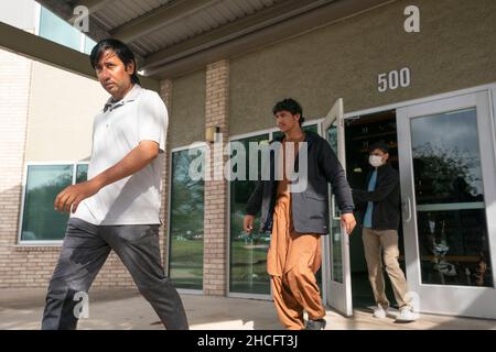 Austin Texas USA, décembre 2021 : les réfugiés afghans quittent le bureau des services aux réfugiés du Texas après avoir rencontré leurs travailleurs de cas.Les réfugiés fuyant la tourmente en Afghanistan continuent d'être réinstallés au Texas, de nombreux hommes célibataires et de grandes familles avec des enfants déménagent dans des appartements à Austin et ont besoin d'une variété de services sociaux.©Bob Daemmrich Banque D'Images