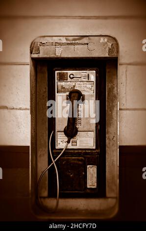 Un téléphone public à pièces appelé également téléphone public est accroché au mur à l'extérieur de Coden Grocery, le 27 décembre 2021, à Coden, en Alabama. Banque D'Images