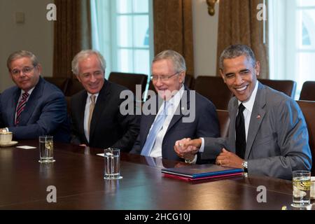 Le président des États-Unis Barack Obama serre la main avec le chef de la majorité au Sénat américain Harry Reid (démocrate du Nevada), lors d'une réunion avec les membres du Congrès sur la politique étrangère dans la salle du Cabinet de la Maison Blanche à Washington, DC, États-Unis, le jeudi 31 juillet,2014. Les États-Unis pourraient limiter le commerce des produits dérivés et les prêts à court terme avec les entreprises russes si les sanctions déjà imposées ne parviennent pas à influencer le président russe Vladimir Poutine pour mettre fin au soutien aux rebelles dans l'est de l'Ukraine.De gauche à droite : le sénateur américain Robert Menendez (démocrate du New Jersey), le sénateur américain Bob Corker (républicain de Tenn Banque D'Images