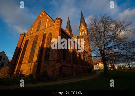 Neuruppin, Allemagne.20th décembre 2021.Le soleil couchant baigne l'église monastère de Saint Trinitatis dans une lumière chaude.Credit: Monika Skolimowska/dpa-Zentralbild/ZB/dpa/Alay Live News Banque D'Images