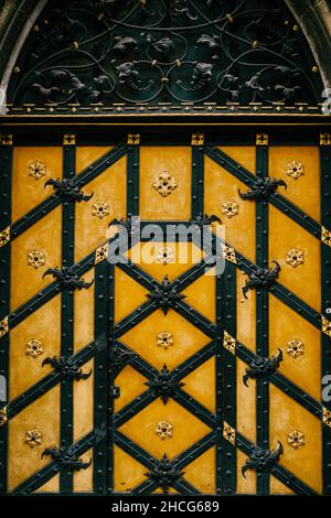 Porte en bois jaune, éléments en fer forgé, décoration florale Banque D'Images