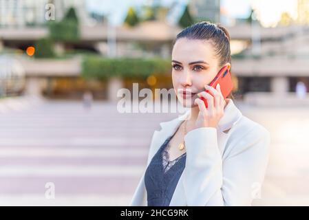 femme sérieuse et concentrée qui parle au téléphone Banque D'Images