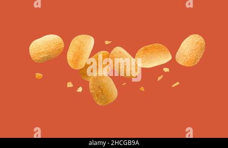 Chips de pommes de terre volantes sur fond rouge. Banque D'Images