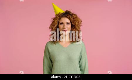 gaie rouge tête et maure femme en tête de fête regardant la caméra isolée sur rose Banque D'Images