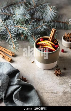 Traditionnel Noël boisson chaude de vacances vigne muffée avec épices, tranches d'orange et canneberge et serviette verte sur fond texturé Banque D'Images