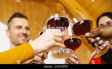 Des amis heureux s'amuser en intérieur - des jeunes qui apprécient le temps ensemble à la maison - concept d'amitié pour les jeunes - des mains toasting verre de vin rouge à hom Banque D'Images
