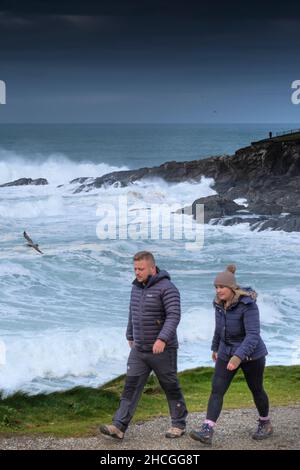 Les marcheurs profitent d'une promenade le long du sentier côtier et regardent vers les mers agitées à Towan Head à Newquay, dans les Cornouailles. Banque D'Images