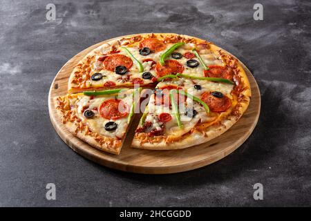 Pizza suprême traditionnelle sur pierre noire Banque D'Images