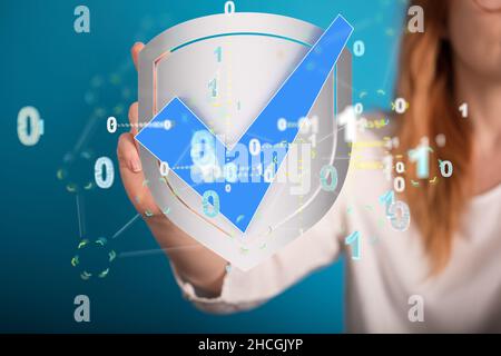 La main de la femme touchant le bouclier rendu de 3D avec une coche et des nombres binaires. Cybersécurité. Banque D'Images