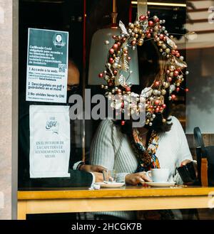 Grenade, Espagne - 28 décembre 2021 : panneau sur la fenêtre du restaurant relatif à la conformité Covid Passport pour consommer dans les locaux d'accueil à Banque D'Images