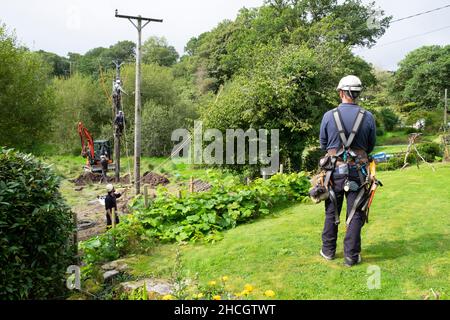 Lignes d'électricité hommes travaillant avec l'équipement et de la digue de mise en place de nouveau poteau de service en été Carmarthenshire pays de Galles Royaume-Uni 2021 Grande-Bretagne KATHY DEWITT Banque D'Images