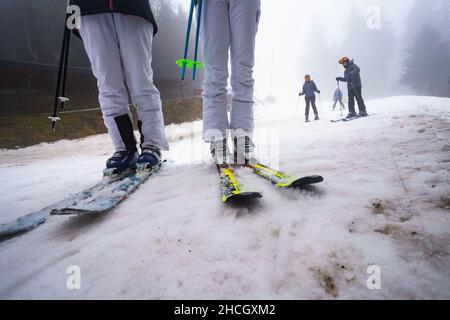 Abtsroda, Allemagne.29th décembre 2021.Les skieurs attendent à la station de la vallée de la Märchenwiesenlift sur la Wasserkuppe.Avec des températures supérieures au point de congélation, les sports d'hiver étaient encore possibles sur la pente de neige artificielle et tassée.Credit: Frank Rumpenhorst/dpa/Alay Live News Banque D'Images