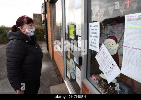 Etwall, Derbyshire, Royaume-Uni.29th décembre 2021.Une femme regarde un panneau informant de l'absence de tests de débit latéral Covid-19 suspendu dans la fenêtre d'une pharmacie après que les pharmaciens ont averti de l'existence de fournitures inégales de tests rapides Covid suite à des changements aux règles d'auto-isolement.Credit Darren Staples/Alay Live News. Banque D'Images