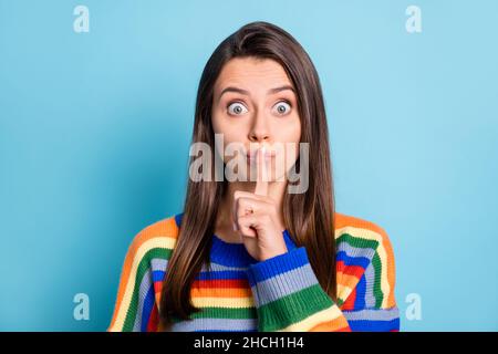 Portrait d'une jolie mystérieuse fille à poil brun émerveillé montrant le signe shh OOPS isolé sur fond bleu vif Banque D'Images