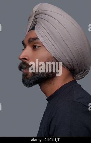 Un homme indien charmant et attentionné dans le turban qui regarde loin Banque D'Images