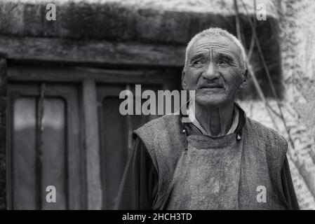 Stakna, Inde - 23 août 2015 : un portrait en noir et blanc d'un moine bouddhiste avec un regard intense se réunit dans la rue du monastère de Stakna Banque D'Images