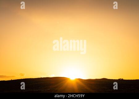 Le soleil se lève au lever du soleil sur les terres silhouettes de Monument Valley Banque D'Images