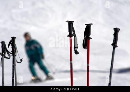 Bâtons de ski enlisés dans la neige avec skieur, sports d'hiver dans les Alpes Banque D'Images