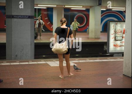 Jeune femme avec pigeon attendant sur la piste dans la station de métro, Hanovre, Basse-Saxe, Allemagne Banque D'Images