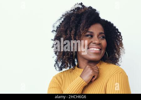 Portrait d'une jeune femme heureuse souriant vêtue d'une chemise jaune, regardant bien Banque D'Images