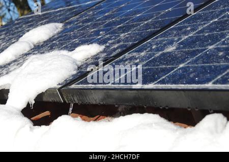 Panneaux solaires couverts de neige et de glace.Installation d'électricité photovoltaïque sur le toit de la maison.Saison d'hiver par jour ensoleillé.Alternative PV énergie pro Banque D'Images